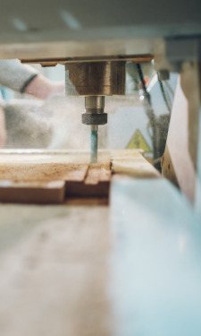 Close-up of a CNC router bit cutting into board