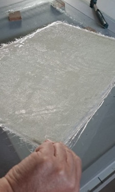 Laying up a fibreglass sheet by hand